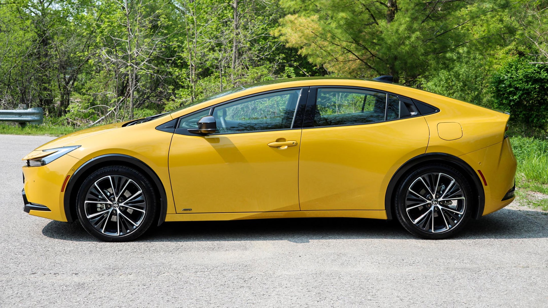 Side profile of a Toyota Prius, a compact car available in various colors, showcasing its sleek design.