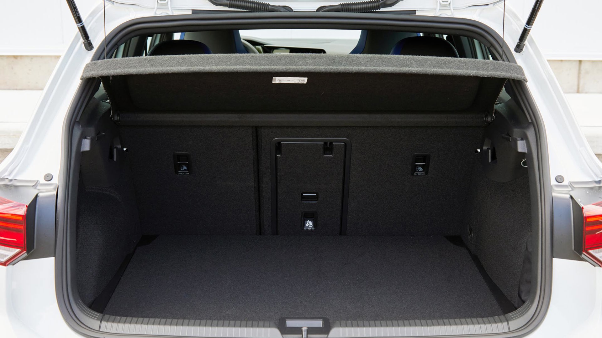 An open trunk of a Volkswagen Golf R, showcasing its spacious and empty interior..