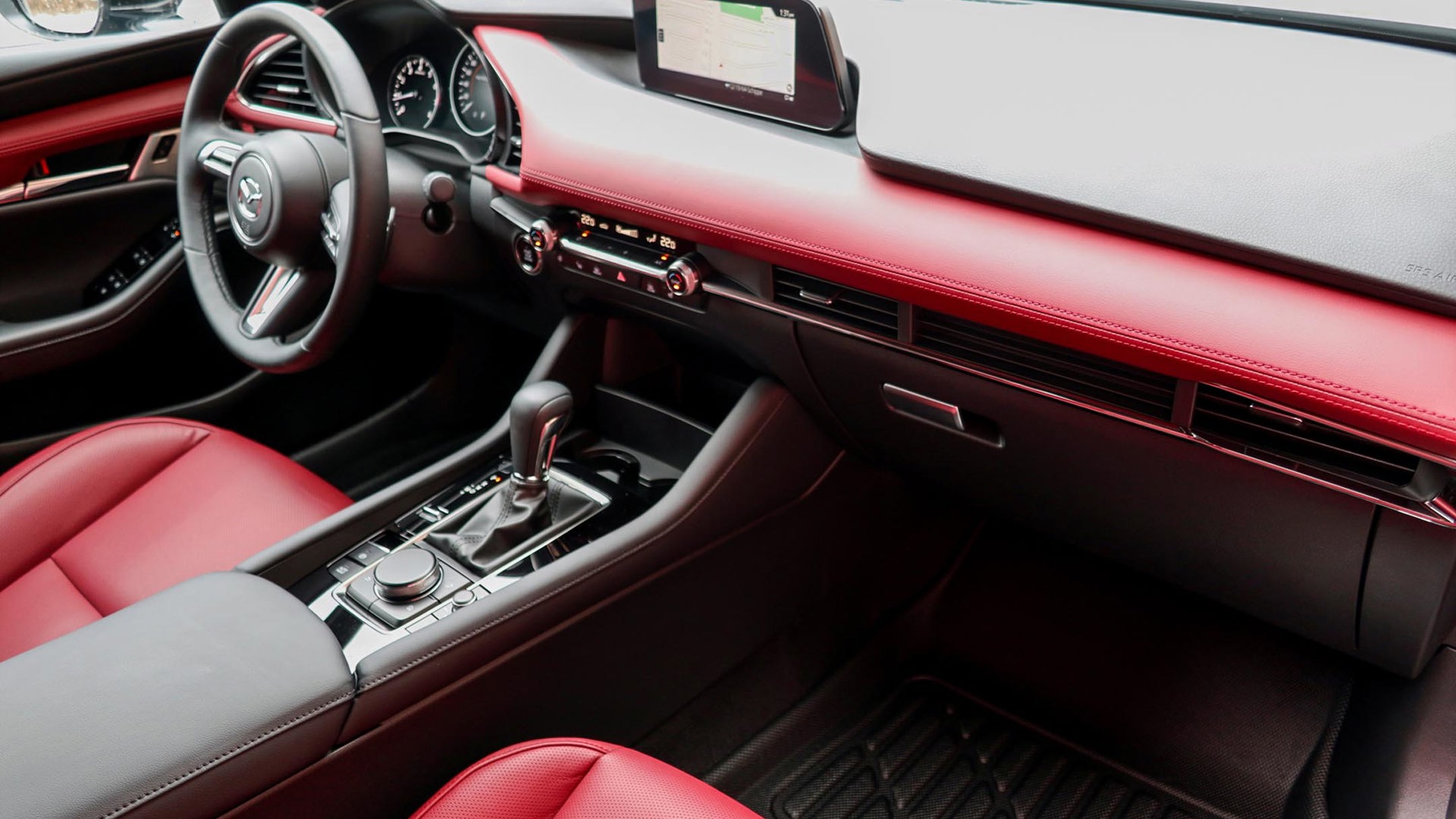 The interior of a Mazda 3 Sport GT Turbo, featuring vibrant red upholstery and modern design elements.