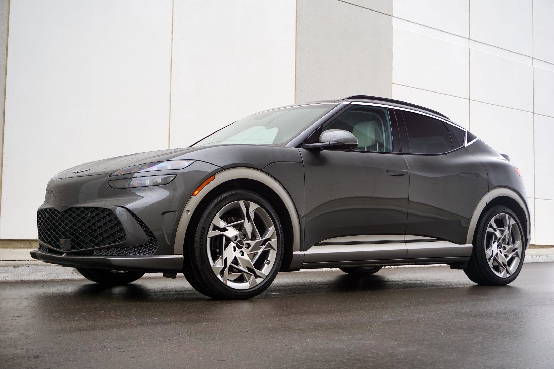 Grey 2024 Genesis GV60 Performance AWD in front of a white garage door