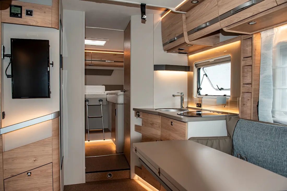 Das Verstauen von Lebensmitteln und Kochgeschirr gelingt dank zahlreicher Ablagefächer und Hängeschränke problemlos. Der hintere Teil des Fahrzeugs lässt sich durch zwei Türen vom Wohnbereich abtrennen.  Das Verstauen von Lebensmitteln und Kochgeschirr gelingt dank zahlreicher Ablagefächer und Hängeschränke problemlos. Der hintere Teil des Fahrzeugs lässt sich durch zwei Türen vom Wohnbereich abtrennen.