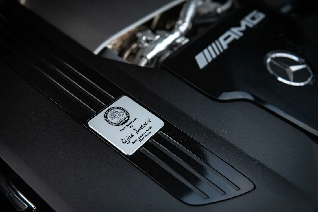 "Ein Mann, ein Motor" - die großen AMG-Motoren werden weiterhin per Hand von nur einem Angestellten zusammengebaut. Den Namen verrät die Plakette im Motorrraum.  "Ein Mann, ein Motor" - die großen AMG-Motoren werden weiterhin per Hand von nur einem Angestellten zusammengebaut. Den Namen verrät die Plakette im Motorrraum.